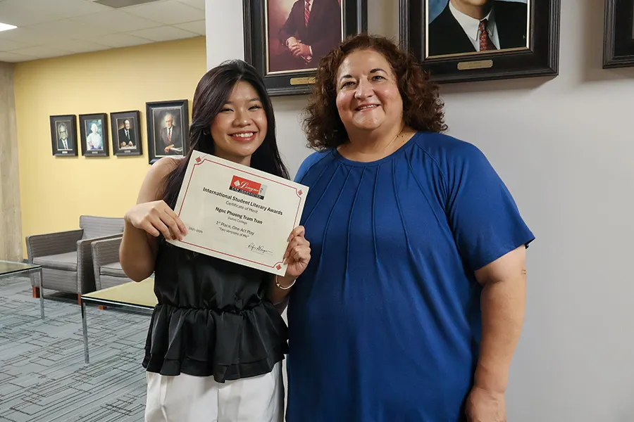 Ngoc Phuong Tram Tran holds her award while she poses with her instructor.