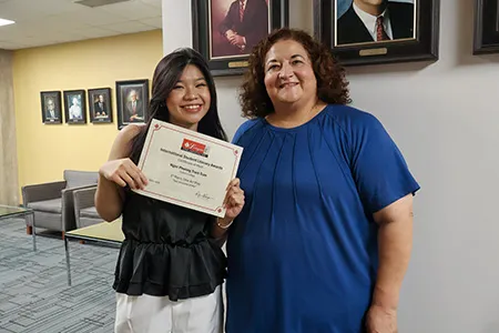Ngoc Phuong Tram Tran holds her award while she poses with her instructor.