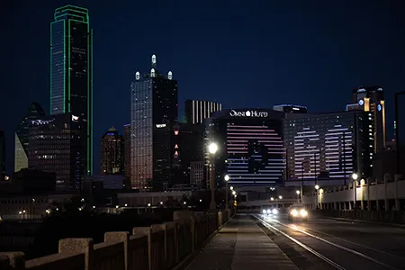 The Dallas College logo is displayed on the side of the Omni hotel in downtown Dallas