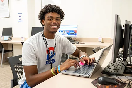 A student looks up from a laptop computer.