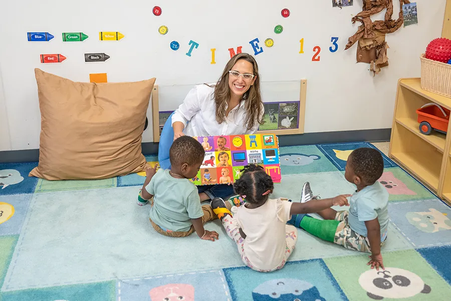 Teacher sitting with 3 students in classroom
