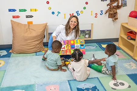 Teacher sitting with 3 students in classroom