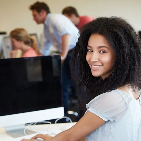 Student at computer desk in collaborative workspace