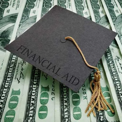 Graduation cap labeled 'Financial Aid' resting on a pile of hundred-dollar bills