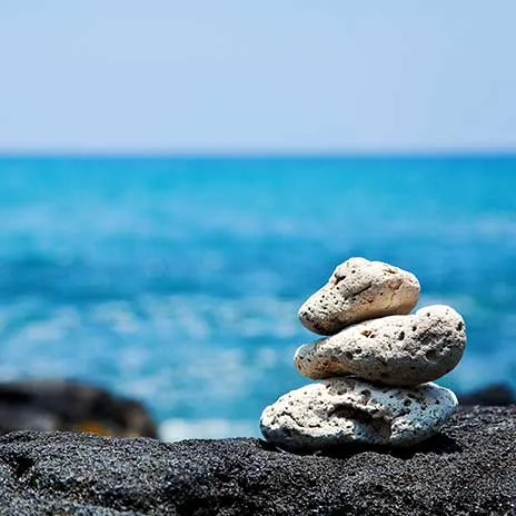 Stacked white stones by the ocean