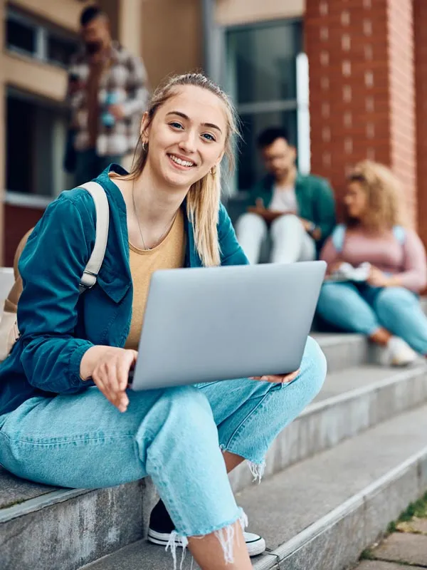 Student sitting on stairs on her laptop