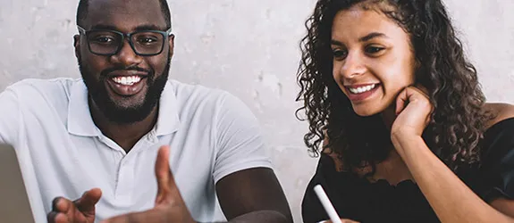 Two students sit at a desk and study together