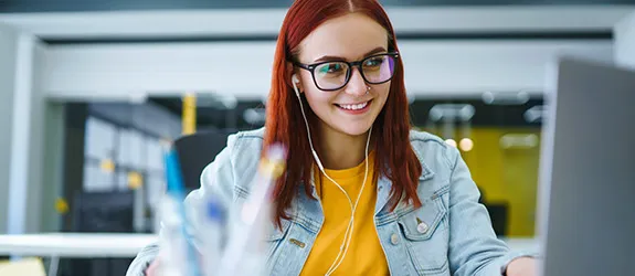 Student sits in front of a computer at a desk