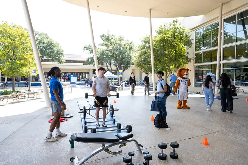 a student lifting weights at a wellness fair