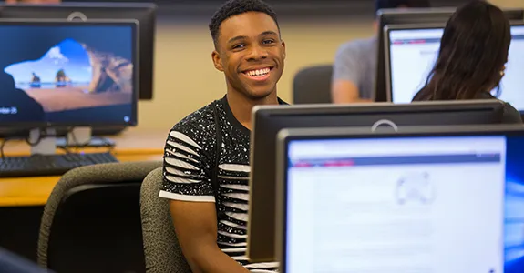 A student looks over their computer monitor