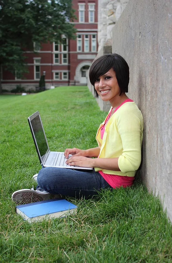 Student outdoors on a laptop