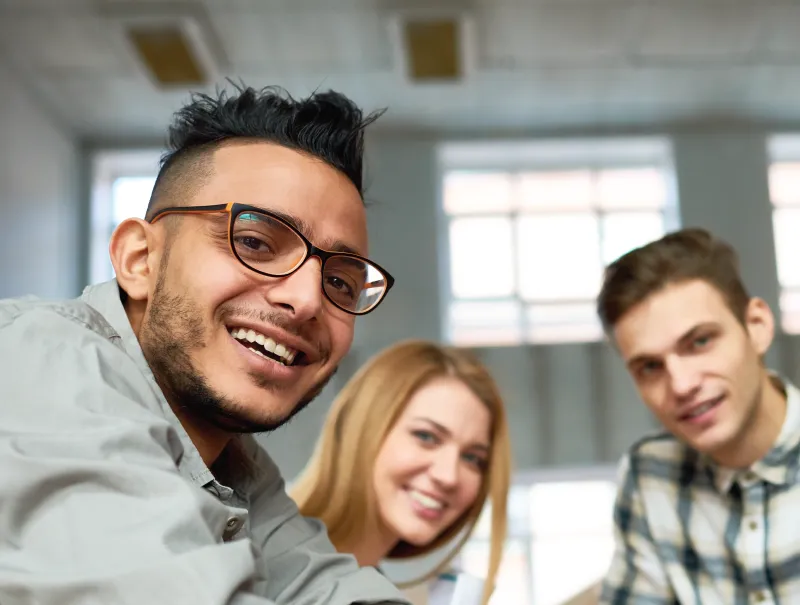 four students smiling and sitting together