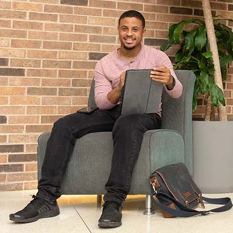 Student sitting down smiling