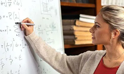 Image of a teacher at a whiteboard teaching math