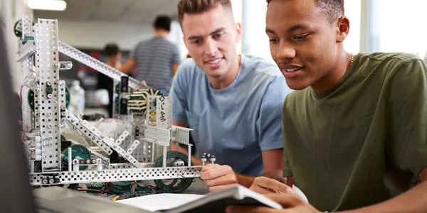 Image of two students with robotic structures in a classroom