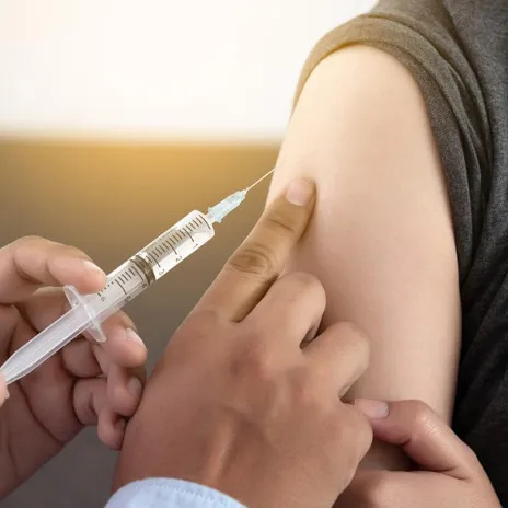 A person gets a vaccine shot in their upper arm
