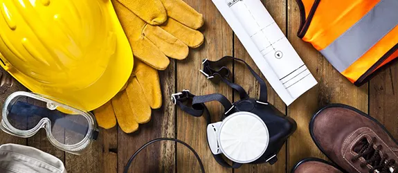 construction worker gear laid out on a wooden floor