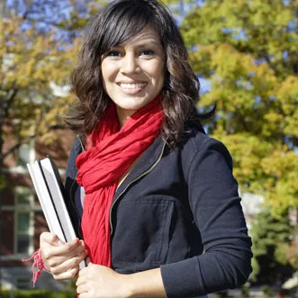 a college student standing outside with their notebooks