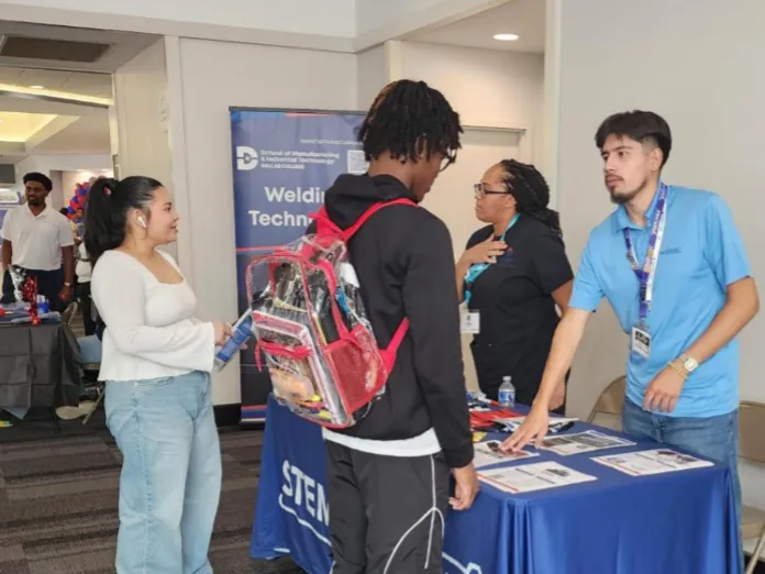 STEM League Ambassadors talk to other students at an event booth