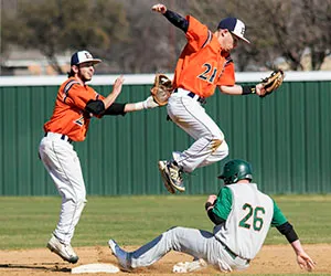 An Eastfield player jumps to grab a ball over a sliding base runner
