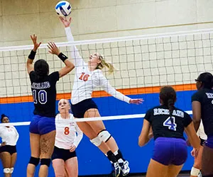 An Eastfield volleyball player spikes the ball over the net