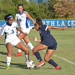 A North Lake women's soccer player tries to dribble the ball past her oppontent