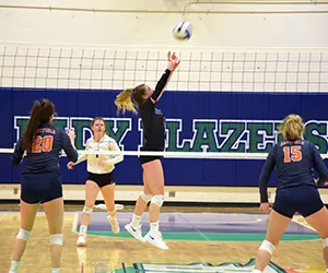 A North Lake volleyball player jumps to set a teammate for a spike