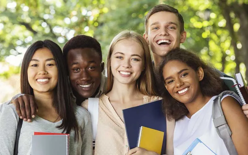 A group of students huddle together for a photo