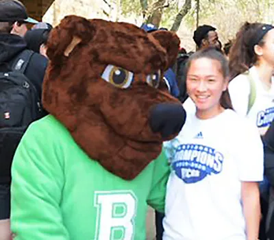 The Brookhaven Bear mascot stands with a student during a campus event