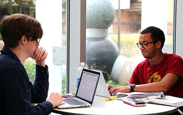 Students study with their laptops at a table at Richland