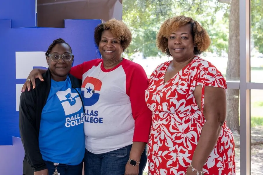 Employees wearing Dallas College tshirts pose for a photo