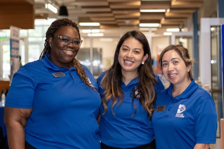 Three employees stop for a photo together at the West Dallas Center