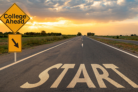 Road with the word start and a sign for college ahead
