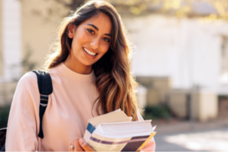 A photo of a college student holding books