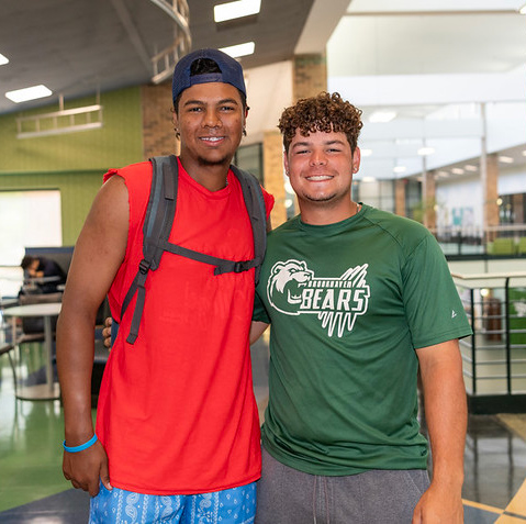 two male students smiling and posing together