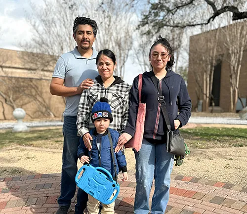 family with mom and dad and two kids posing outside
