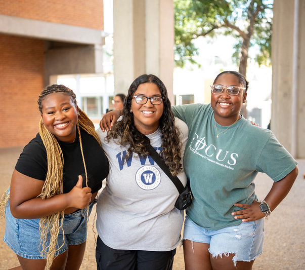 three female student smiling and posing together