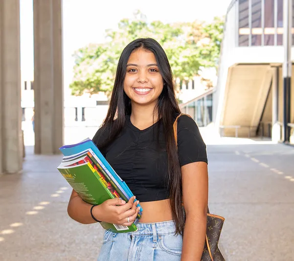 female student holding books and smiling
