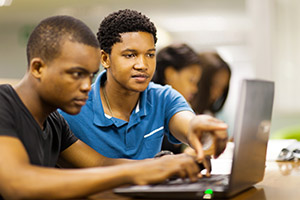 Two students on a laptop working together