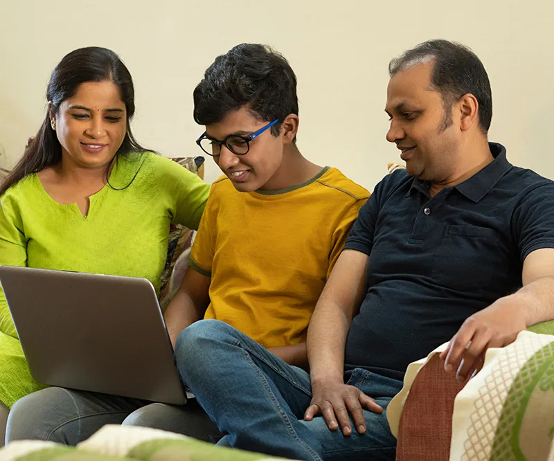 a son sitting on couch with his parents