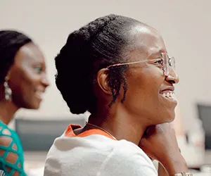 A student smiles while listening to an instructor during class