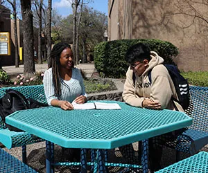 Students study at an outdoor table at Cedar Valley
