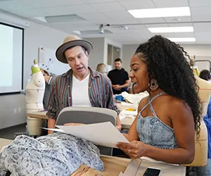 Two students discuss a clothing design in class at El Centro