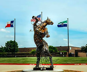 The North Lake Blazer statue in the main campus circle with flags in the background