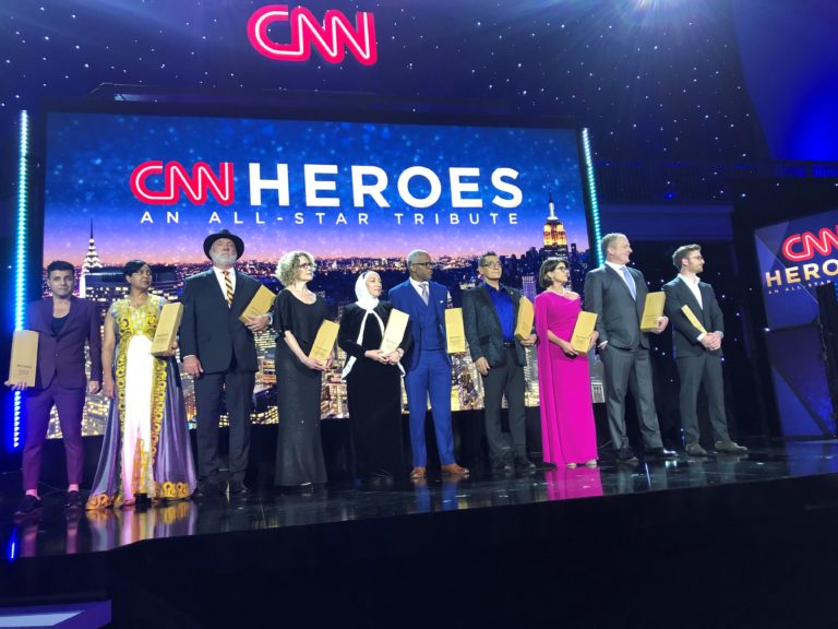 10 CNN Heroes award winners on stage holding awards.