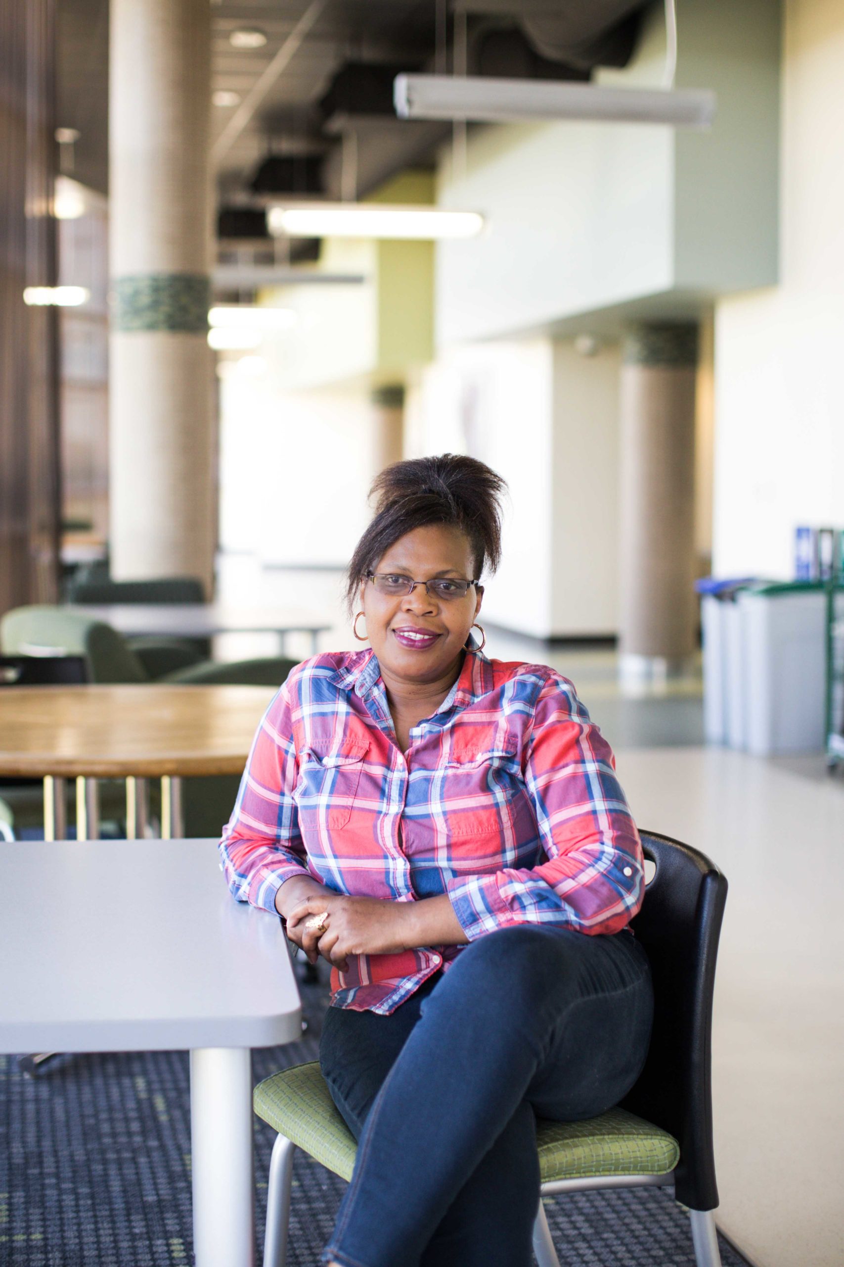 Teresiah Njenga sitting at a table on campus.