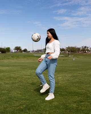 Paris Sithavong bouncing soccer ball.