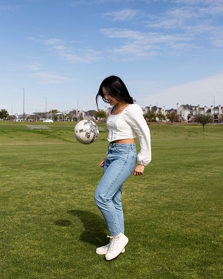 Paris Sithavong bouncing soccer ball.