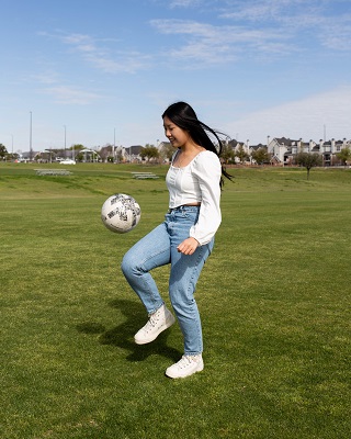 Paris Sithavong bouncing soccer ball.