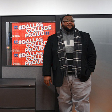 Brian Daniels standing in front of Dallas College Proud posters.